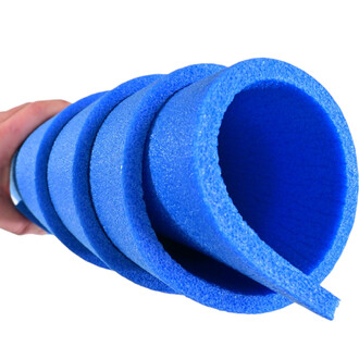 Mousse de gymnastique bleue enroulée et tenue à la main, montrant plusieurs sections de forme cylindrique.