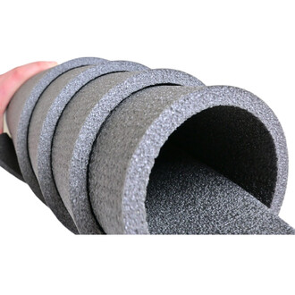 Mousse de gym en rouleaux gris, empilés et tenus à la main, montrant les bords texturés et l'intérieur creux.