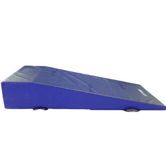 Plan incliné à plateforme A de couleur bleue, de forme rectangulaire avec une pente douce. Sa surface est lisse et rembourrée, conçue pour la pratique des acrobaties ou des exercices de jonglerie. Des pieds en matériau solide assurent la stabilité.