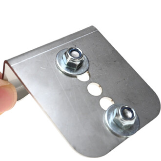 Talonette en inox avec deux vis et un trou pour ajustement, tenue par une main.