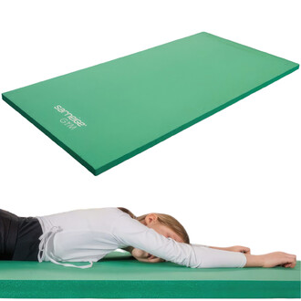 Tapis compact scolaire de couleur verte, avec une personne allongée dessus, les bras étendus. Le tapis est bien matelassé, adapté pour des activités scolaires.